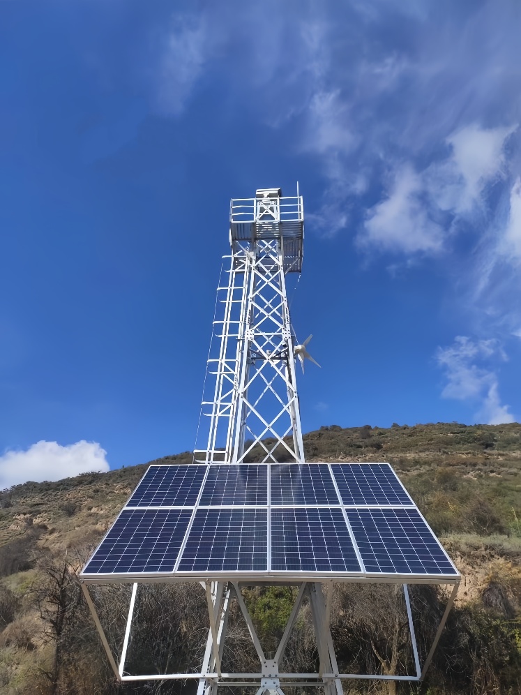 CCTV surveillance tower with elevated solar panels in fire-prone forest area