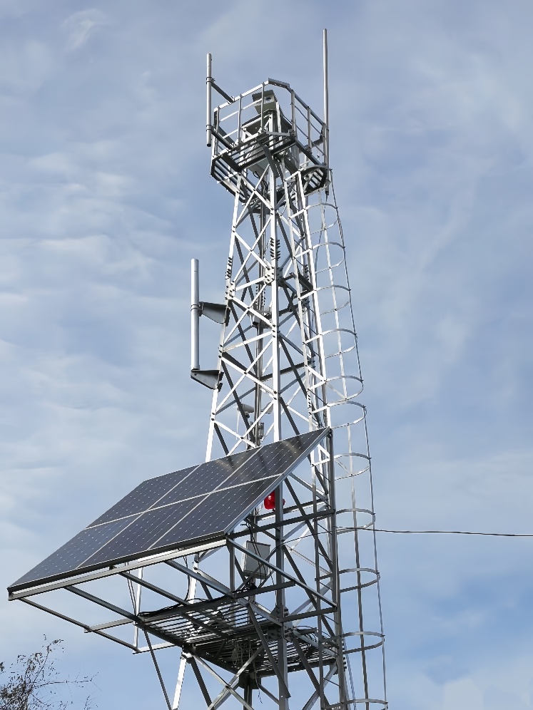 High surveillance tower with solar panel and camera setup for early forest fire alert
