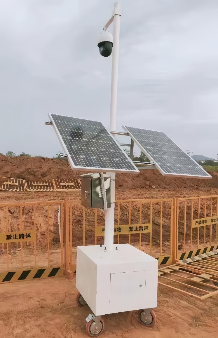 Mobile solar-powered surveillance trailer with dual panels deployed at construction site for off-grid security monitoring