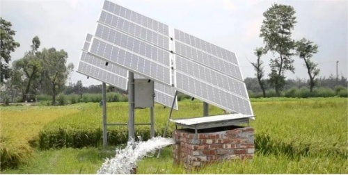 A large solar array powers an off-grid irrigation well in a rice field, delivering sustainable water supply for crops