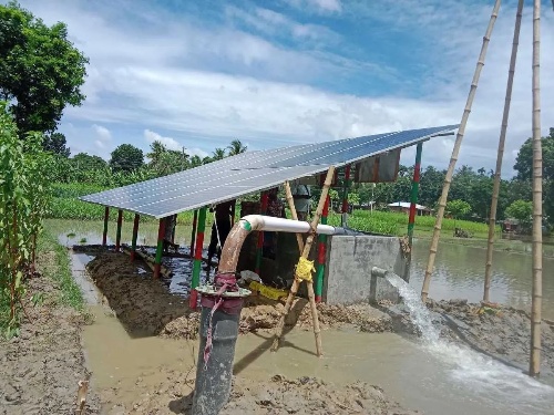 An off-grid solar irrigation system powers a water pump in a flooded paddy field, showcasing rural deployment in wet agricultural zones