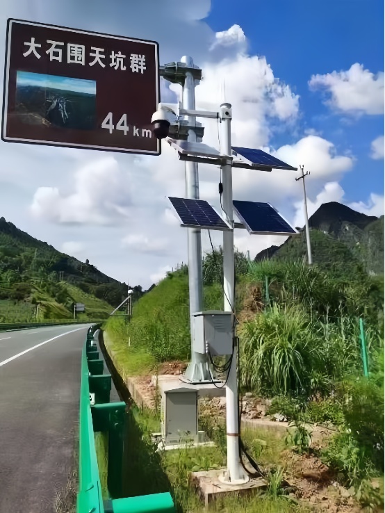 A roadside solar CCTV installation with multiple panels and surveillance equipment for real-time traffic monitoring on remote expressway routes in mountainous regions
