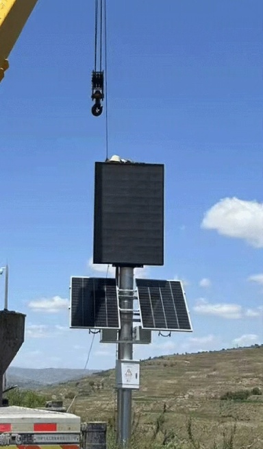 Pole-mounted solar CCTV system with dual panels powering cameras and LED displays in mining environments
