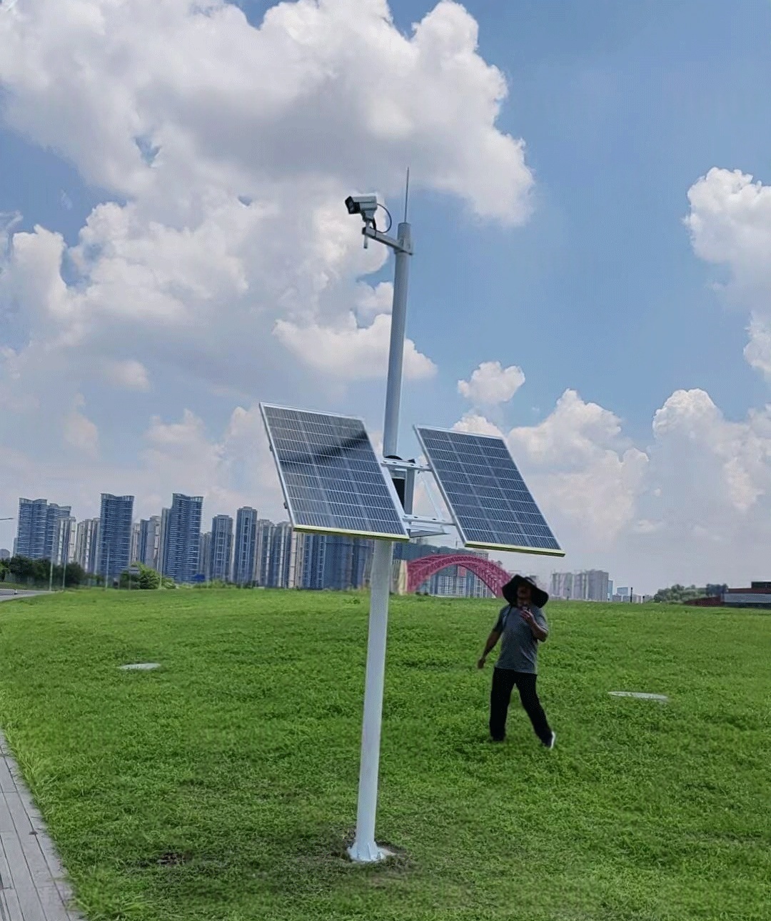 A solar CCTV kit with pole-mounted dual solar panels installed in an urban greenfield provides continuous surveillance for smart city safety projects in China