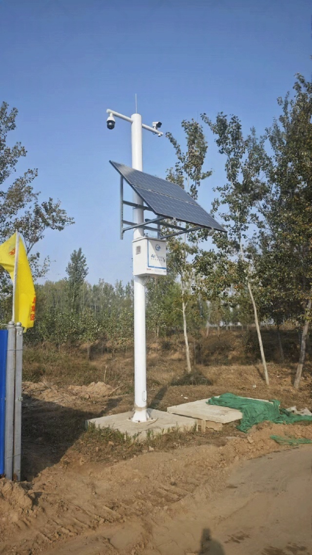 A solar-powered monitoring pole with a multi-panel array operating in a water-management area of Shijiazhuang, supporting cameras and sensors for continuous hydrological data collection