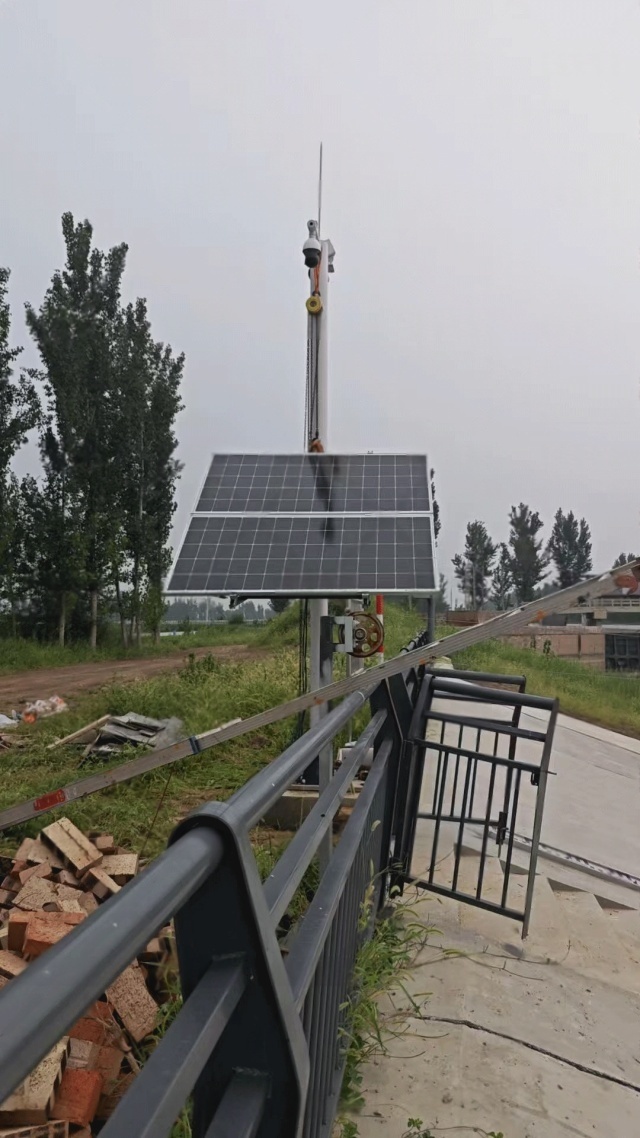 A close-up view of a solar-powered monitoring unit installed beside a canal in Shijiazhuang, showing the photovoltaic panel, camera, and support structure designed for stable hydrological monitoring