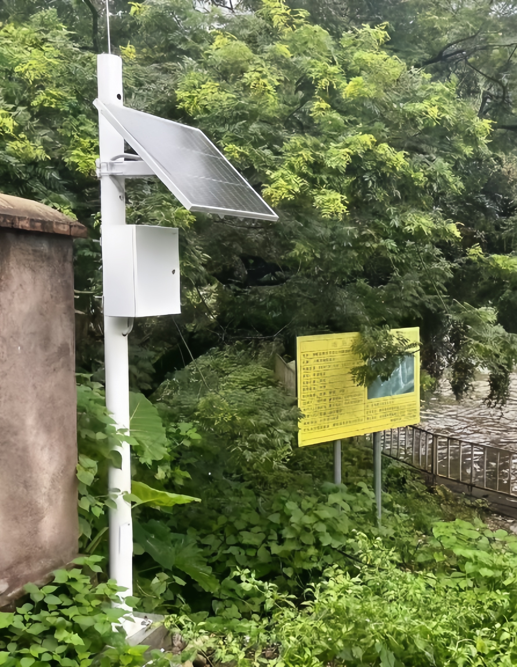A full view of the solar power kit for water level monitoring installed on Wuhan riverbanks, featuring a 60W PV panel and integrated 30Ah battery cylinder designed by Shenzhen Kongfar Technology to ensure continuous off-grid hydrological data collection