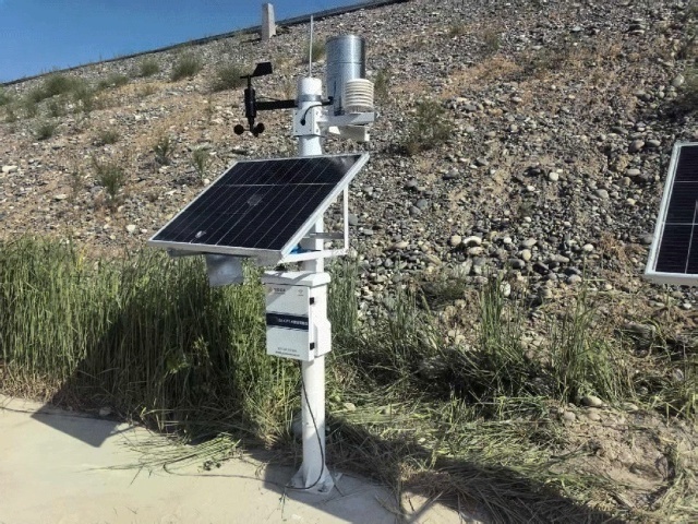 The solar-powered rainfall monitoring unit is installed on a riverbank in Guiyang with elevated brackets that protect against vegetation shading and moisture exposure while maintaining consistent photovoltaic generation during long rainstorms for emergency hydrology surveillance
