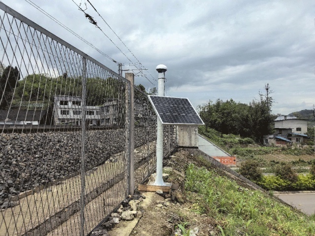 A GNSS slope monitoring station installed on a remote hillside in Burqin, Xinjiang, showing a solar panel, LiFePO4 battery cabin, and GNSS antenna operating in the Altay mountain climate for continuous off-grid monitoring