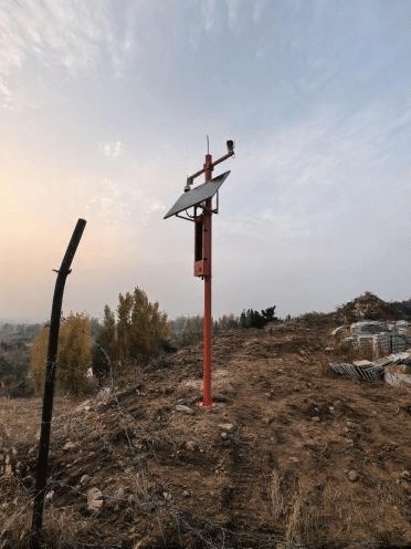 A pole-mounted off-grid solar power system deployed at a mountain forest site in Tai'an, Shandong, supporting continuous forest fire monitoring in remote terrain