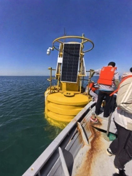 An off-grid solar power system being installed on a marine monitoring buoy during offshore deployment in Dalian, supporting continuous environmental data collection at sea