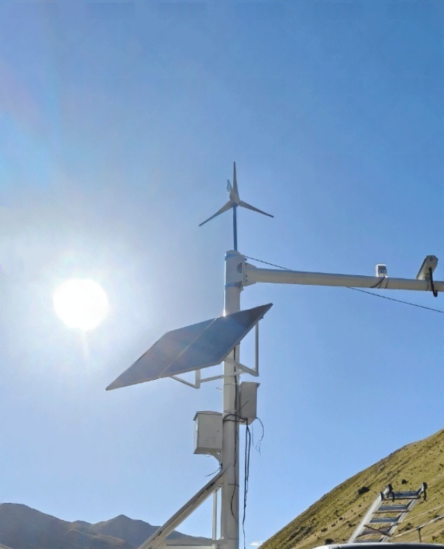 A wind–solar hybrid power system with photovoltaic panels and a small wind turbine installed on a mountain surveillance pole for off-grid security monitoring in Ya'an, Sichuan, China